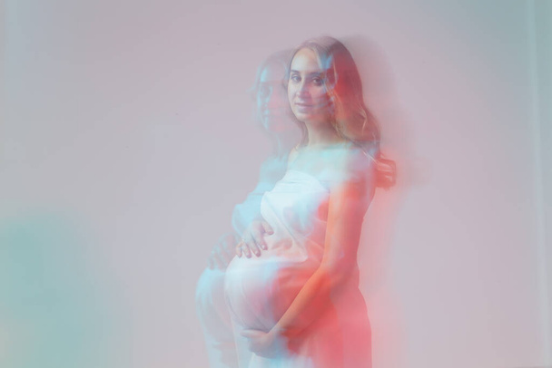 Elegancka, młoda kobieta w ciąży, nosząca lekki materiał. Ciąża, fantazja i koncepcja bajek. - Zdjęcie, obraz