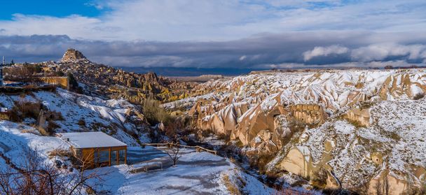 Vista panoramica orizzontale innevata sulla famosa Valle dei Piccioni in Cappadocia, Turchia con camini fatati unici e case di piccioni in inverno - Foto, immagini