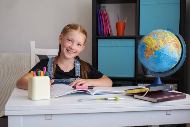  bonito feliz caucasiano ruiva menina estudando em casa - Foto, Imagem