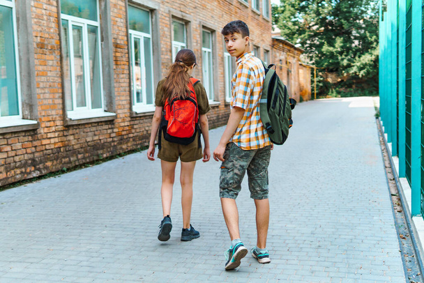 két tinédzser fiú és lány úton az iskolába, az oktatás és vissza az iskolába koncepció - Fotó, kép