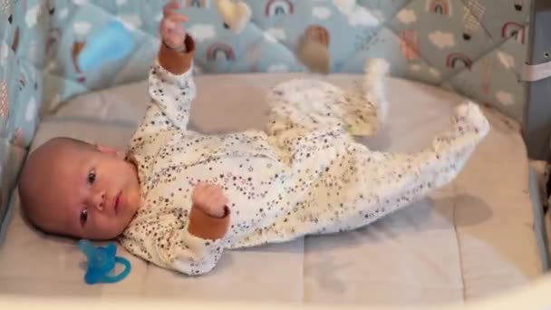 Een pasgeboren baby wil niet slapen in zijn wieg - Video