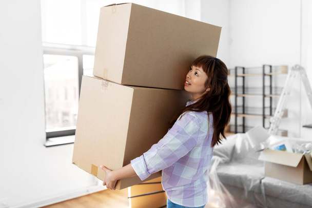 szczęśliwa kobieta trzyma pudełka i przenosi się do nowego domu - Zdjęcie, obraz