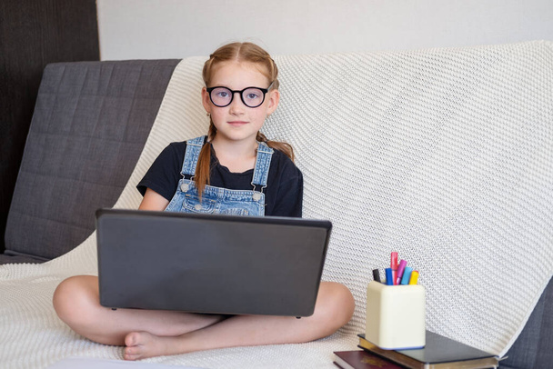  Кавказская счастливая рыжая девушка в очках с ноутбука, учится дома - Фото, изображение