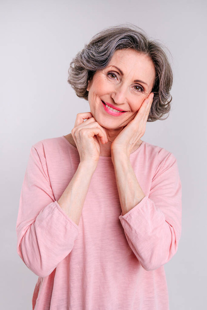 Portrait of happy stylish mature woman on light grey background with blank space for text. - Photo, image