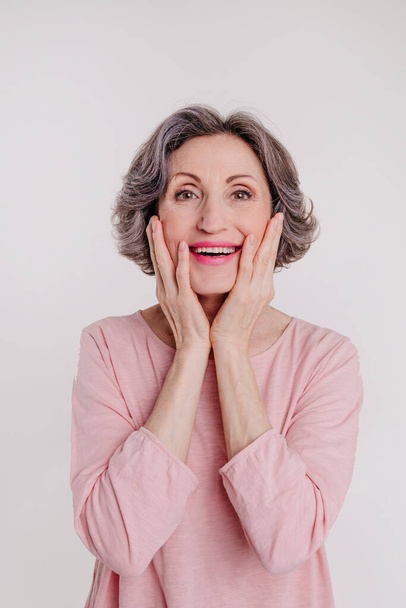 Portrait of happy stylish mature woman on light grey background with blank space for text. - 写真・画像