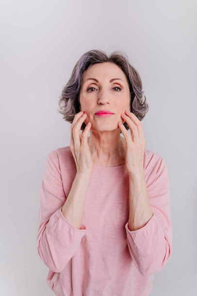 Mature woman making facial exercises to tone and slim face - Photo, Image