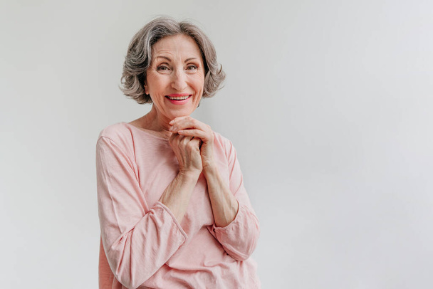 Happy stylish mature woman on light grey background - Photo, Image