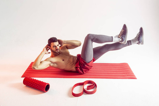 Αθλητής εκπαιδεύσει κοιλιακούς μυς στο στρώμα φυσικής κατάστασης - Φωτογραφία, εικόνα