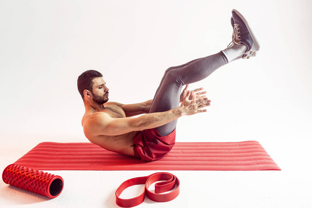 Sportsman entraîner les muscles abdominaux sur tapis de fitness - Photo, image
