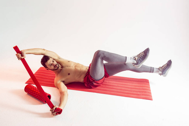 Sportsman train abdominal muscles on fitness mat - Photo, Image