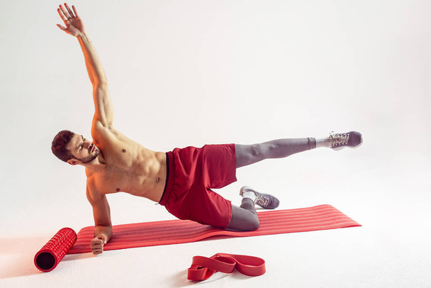 Sportler trainieren Bauchmuskeln auf Fitnessmatte - Foto, Bild