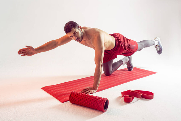 Спортсмен тренирует мышцы живота на тренажерном коврике - Фото, изображение