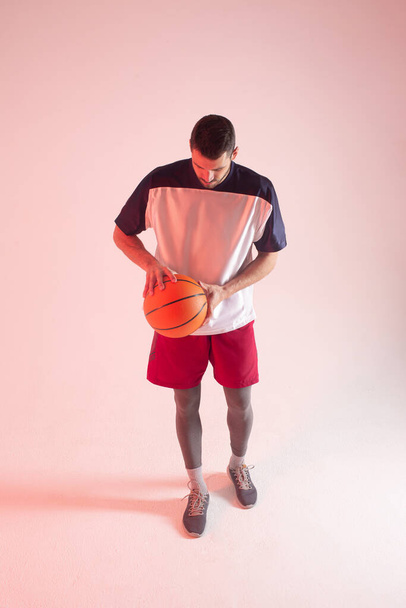 European basketball player holding ball in studio - Φωτογραφία, εικόνα