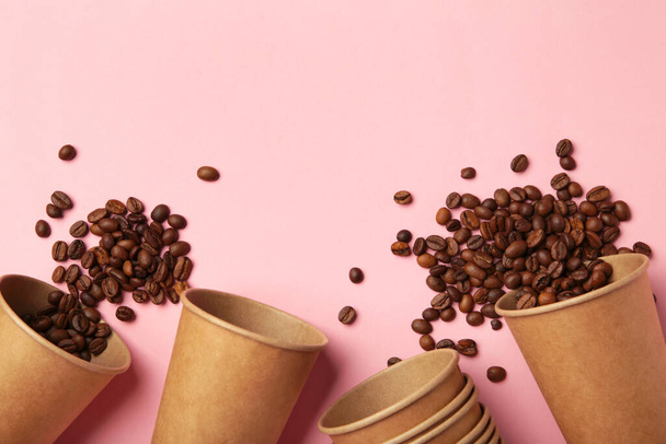 Coffee beans and paper coffee cup on pink background. Top view. - Фото, зображення