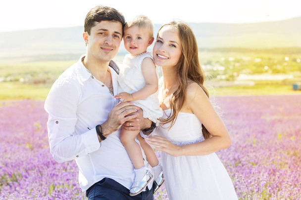 Happy family having fun in lavender field - Foto, afbeelding