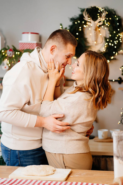 pregnant woman with husband in New Years kitchen prepares and have fun  - Photo, image