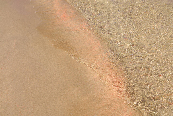 Jasne fale i kolorowy piasek na tropikalnej, piaszczystej plaży na Krecie - Zdjęcie, obraz