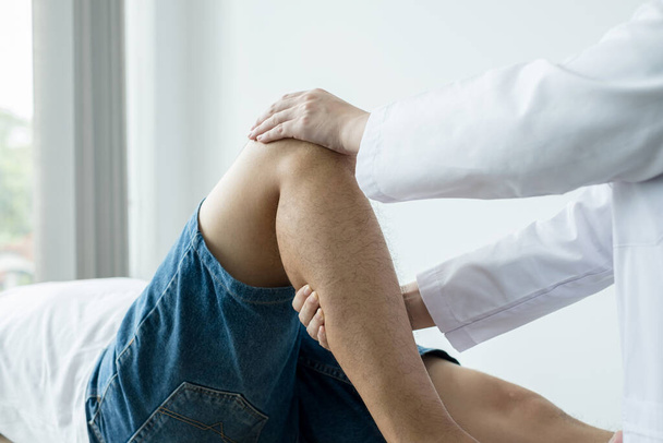 Пацієнти чоловічої статі консультувалися з фізіотерапевтами з проблемами болю в коліні для обстеження та лікування. Реабілітаційна фізіотерапія концепція
. - Фото, зображення