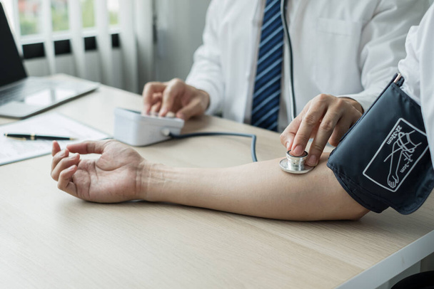 Man doctors measured blood pressure, the patient examined the heartbeat, and talked about health care closely. Medical and health care concepts. - Photo, Image