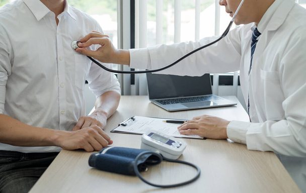 Male doctors perform a pulse test using a stethoscope. Initial health check-up at the hospital. Concepts of treatment and good health. - 写真・画像