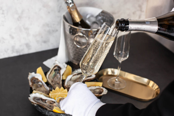 Hand of waiter with white glove pouring champagne - Zdjęcie, obraz