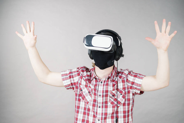 Man playing video game wearing virtual reality device. Gaming equipment for gamers concept. - Foto, Imagen