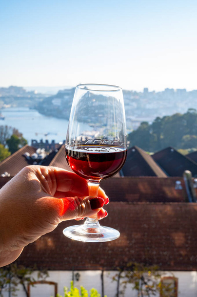Verkostung verschiedener angereicherter Dessertweine Rubin, tawny Portweine in Gläsern mit Blick auf den Douro, Porto Lodges von Vila Nova de Gaia und der Stadt Porto, Portugal, aus nächster Nähe - Foto, Bild
