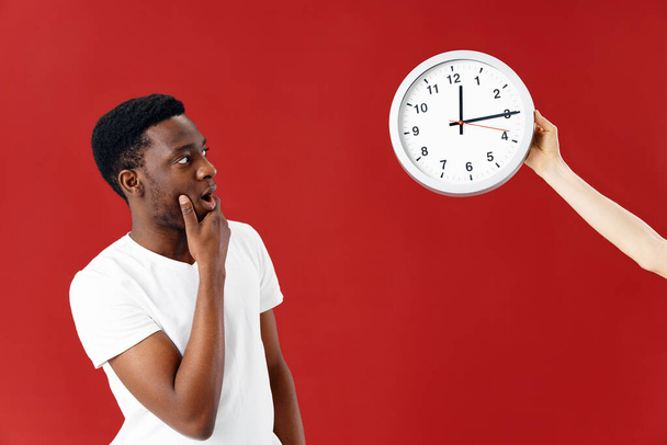 surprised man of african appearance looking at watch studio lifestyle - Valokuva, kuva