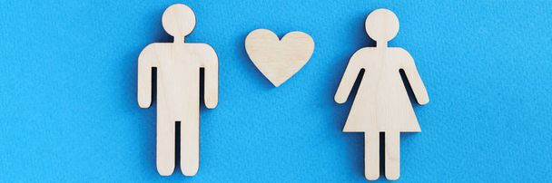 Figurines en bois de l'homme et de la femme avec coeur sur fond bleu - Photo, image
