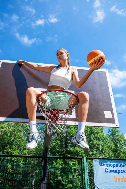 Young beautiful brunette girl posing on the basketball court - 写真・画像