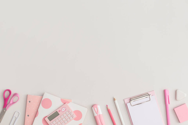 Pink school stationery on a grey background. Top view. Flat lay. Back to school concept. - 写真・画像