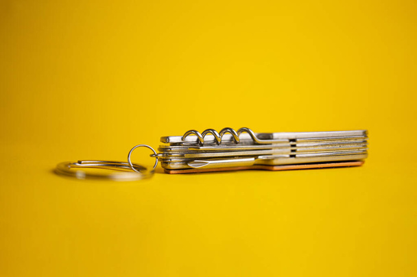 πολυλειτουργικό μεταλλικό μαχαίρι σε κίτρινο φόντο - Φωτογραφία, εικόνα