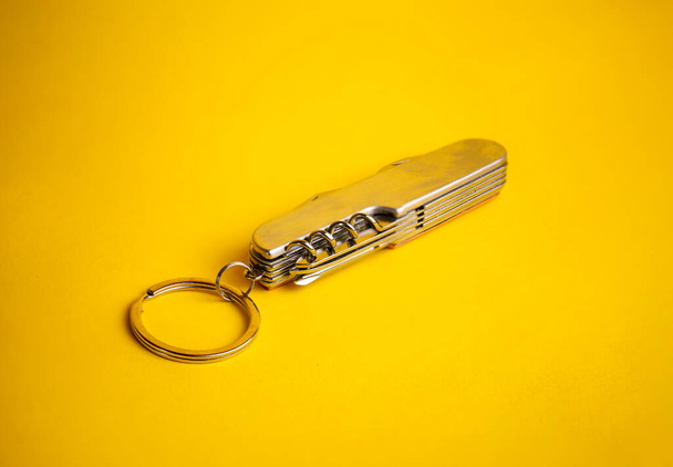 couteau métallique multifonctionnel sur fond jaune - Photo, image