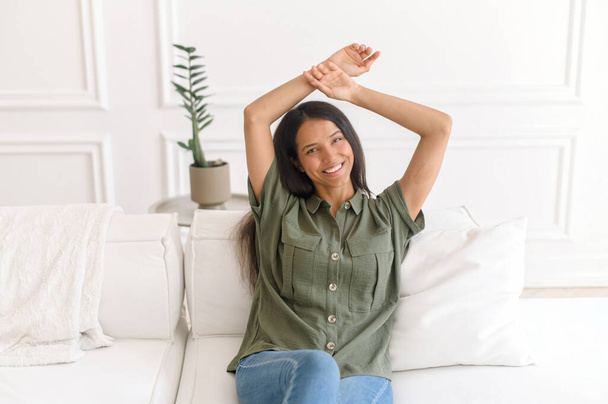 Carefree and serene indian woman resting on the comfortable couch - Foto, imagen