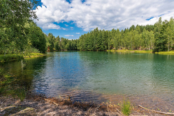 The forest lake, which appeared on the site of quarries, is surrounded by forest on all sides. - Photo, Image