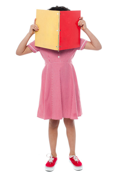 Girl hiding her face behind a book - Fotografie, Obrázek