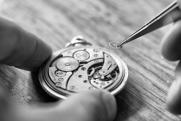 機械式時計修理。時計メーカーはヴィンテージ機械式時計を修理します。時計職人ワークショップ. - 写真・画像
