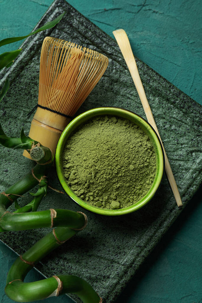 Konzept des japanischen Tees mit Matcha auf grünem, strukturiertem Hintergrund - Foto, Bild