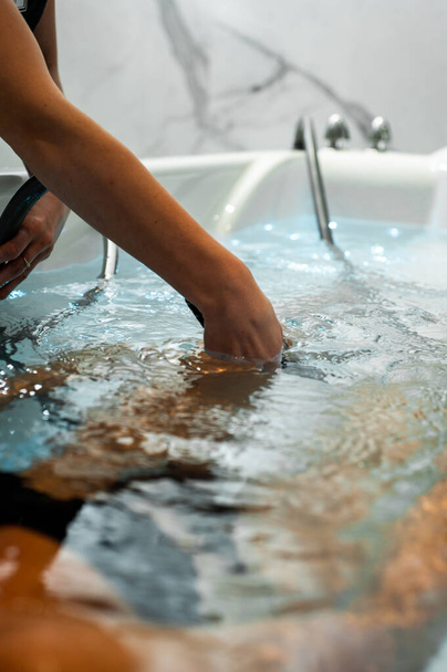 close-up of a female hand  in bath, spa concept - 写真・画像
