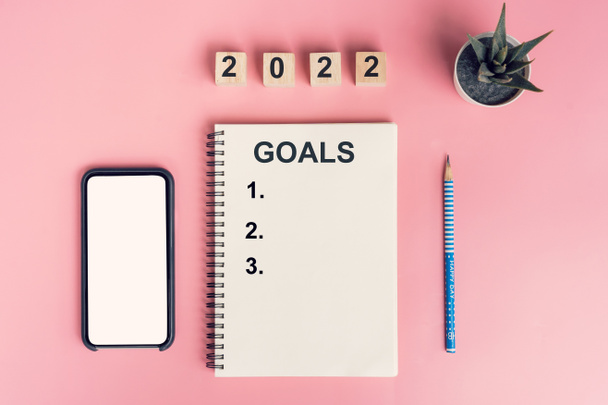 Quaderni con obiettivi vuoti per 2022 anno e telefono su sfondo a colori - Foto, immagini