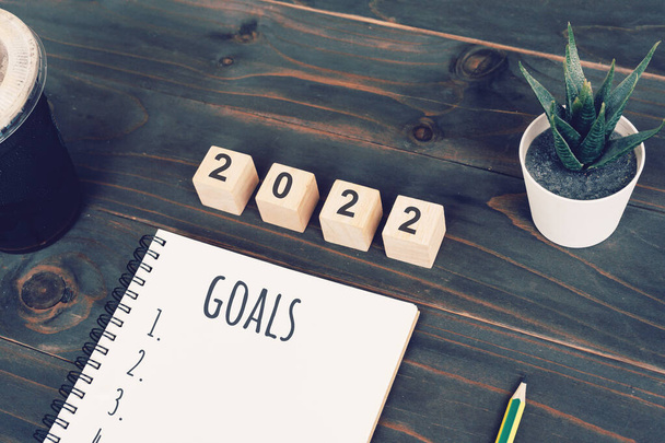 2022 goals text on notepad with coffee cup and pen on wooden desk - Photo, Image