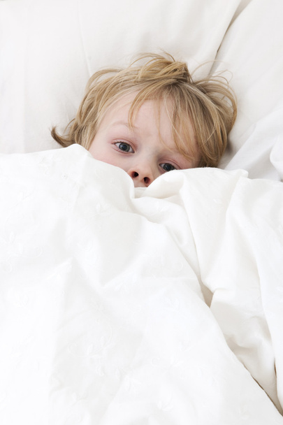 malé dítě, ležící v posteli s očima dokořán, týkající se sám, strach z noční můry, kterou mu - Fotografie, Obrázek