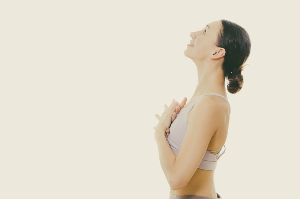 Portrait of gorgeous active sporty young woman practicing breathing exercises in yoga studio. Healthy active lifestyle, working out indoors in gym - Photo, Image