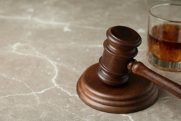 Судья молоток и стакан виски на сером текстурированном столе - Фото, изображение