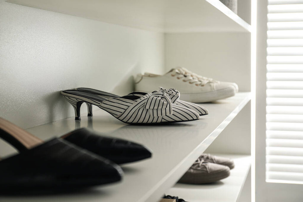 Storage rack with stylish women's shoes indoors, closeup - 写真・画像