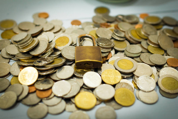 Moneda de dinero y cerradura, sobre fondo gris. Concepto de ahorro y seguridad financiera. - Foto, imagen