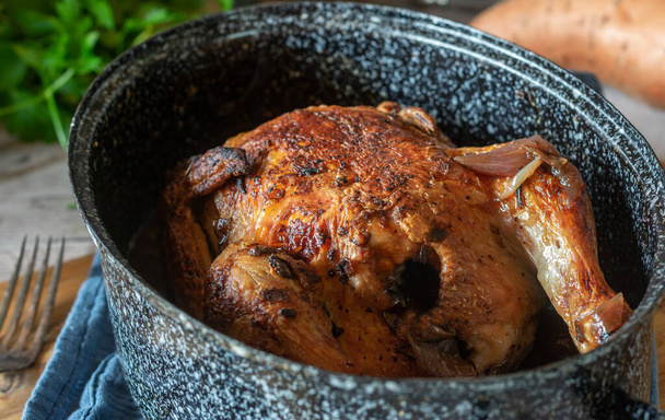 zelfgemaakte vers gekookte gebraden kip geserveerd in een pot of een broodrooster op keukentafel achtergrond van boven. Afzonderlijk en close-up zicht - Foto, afbeelding
