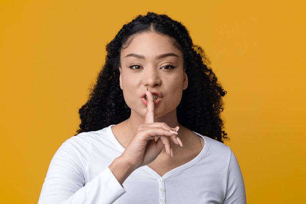 Keep Silence. Black Lady Holding Finger Near Lips And Looking At Camera - Photo, Image