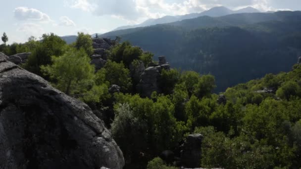 Vista panorâmica da paisagem de penhascos rochosos com árvores verdes rodeadas de montanhas. - Filmagem, Vídeo