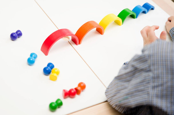Ξύλινο πολύχρωμο ουράνιο τόξο Παιχνίδι για παιδιά διασκέδαση και δημιουργικότητα. Ακολουθία, κινητικές ικανότητες, ψυχοθεραπεία για την εκπαίδευση και την άσκηση του εγκεφάλου. Εφαρμογή τύπου Montessori. - Φωτογραφία, εικόνα